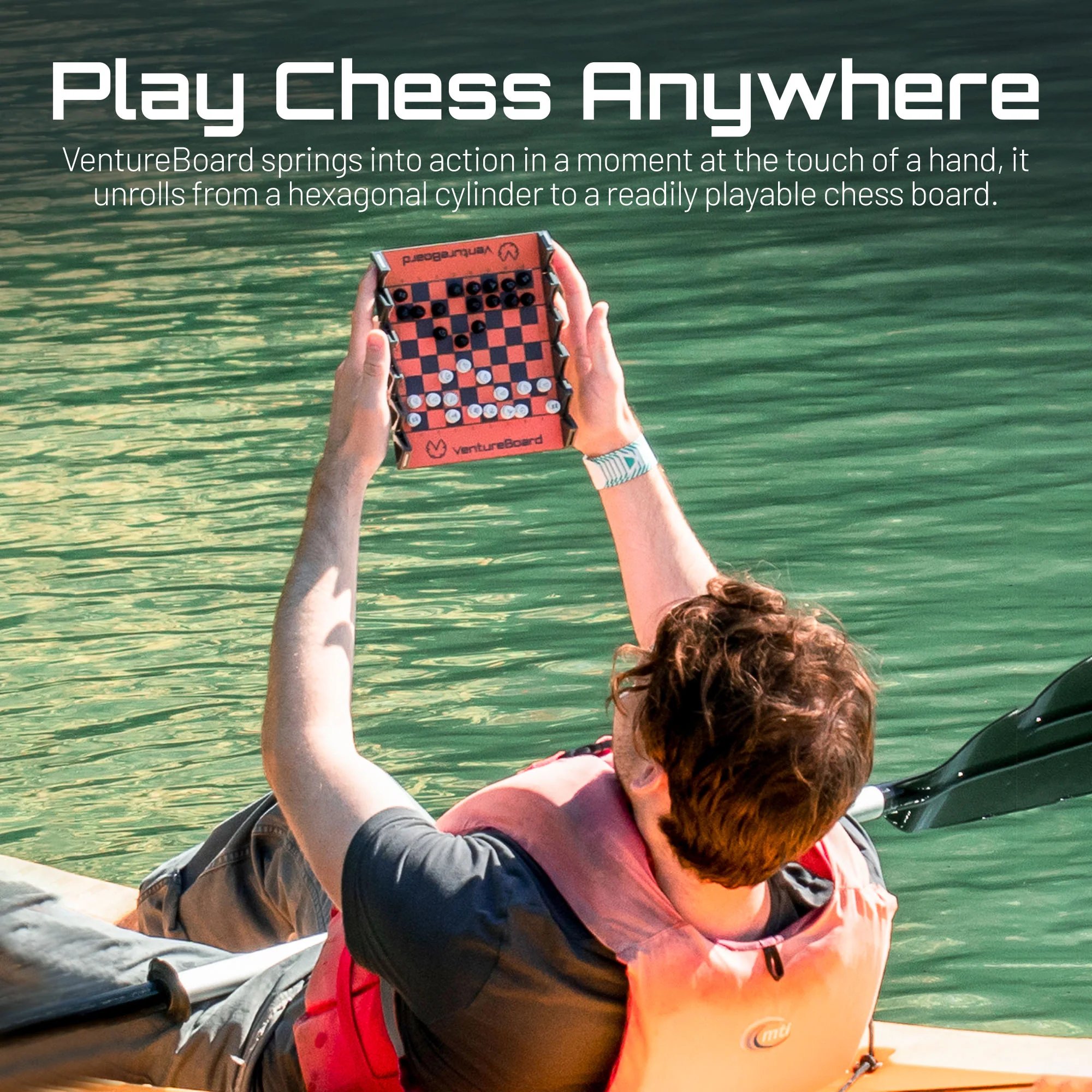 image of man holding portable chess set with magnetic pieces aloft 