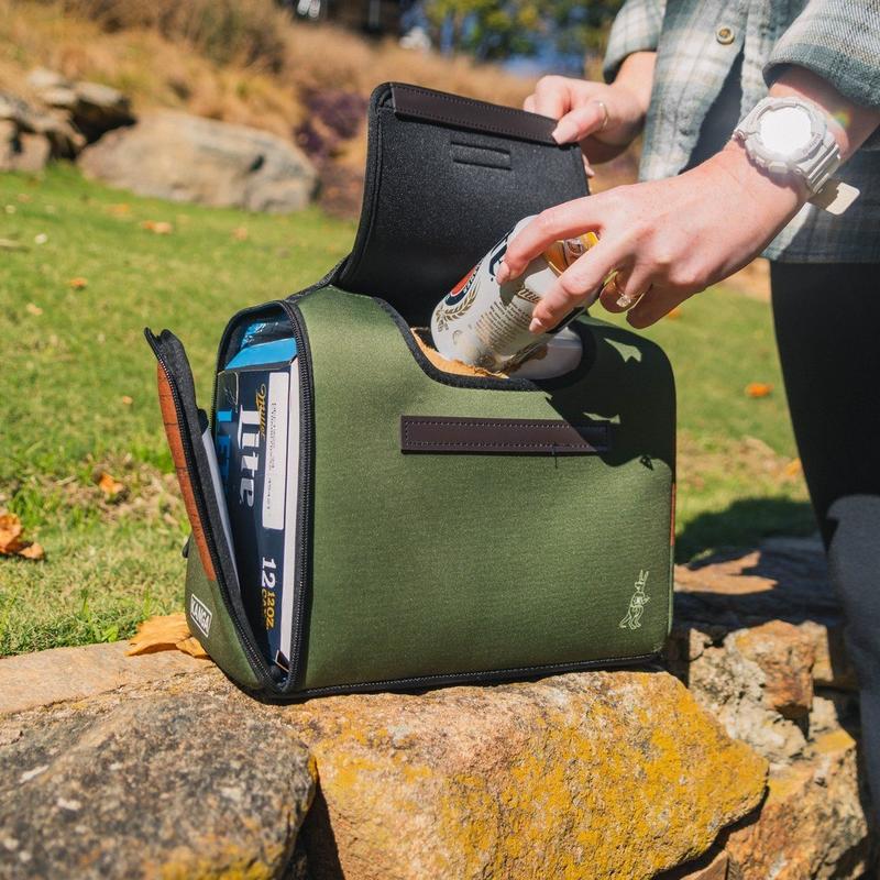 Person grabbing a can from the open cooler bag outdoors